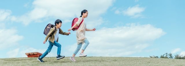女の子と男の子が元気に走っている様子