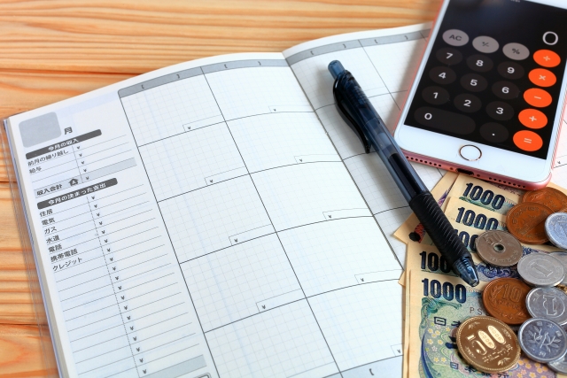 家計簿と計算機と現金の画像